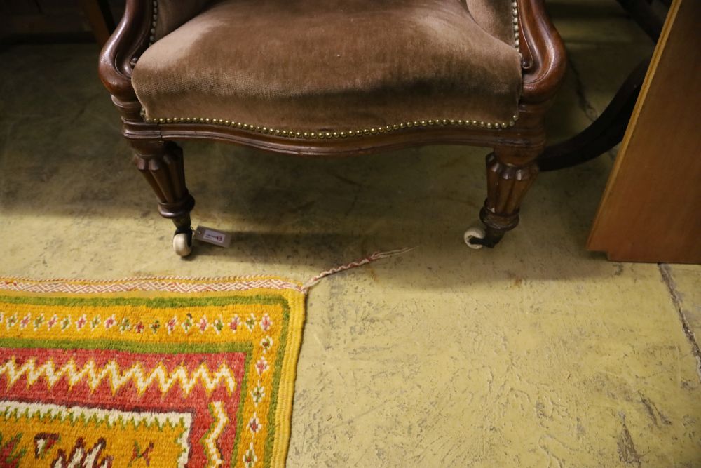 A Victorian mahogany-framed armchair covered in deep-buttoned dralon